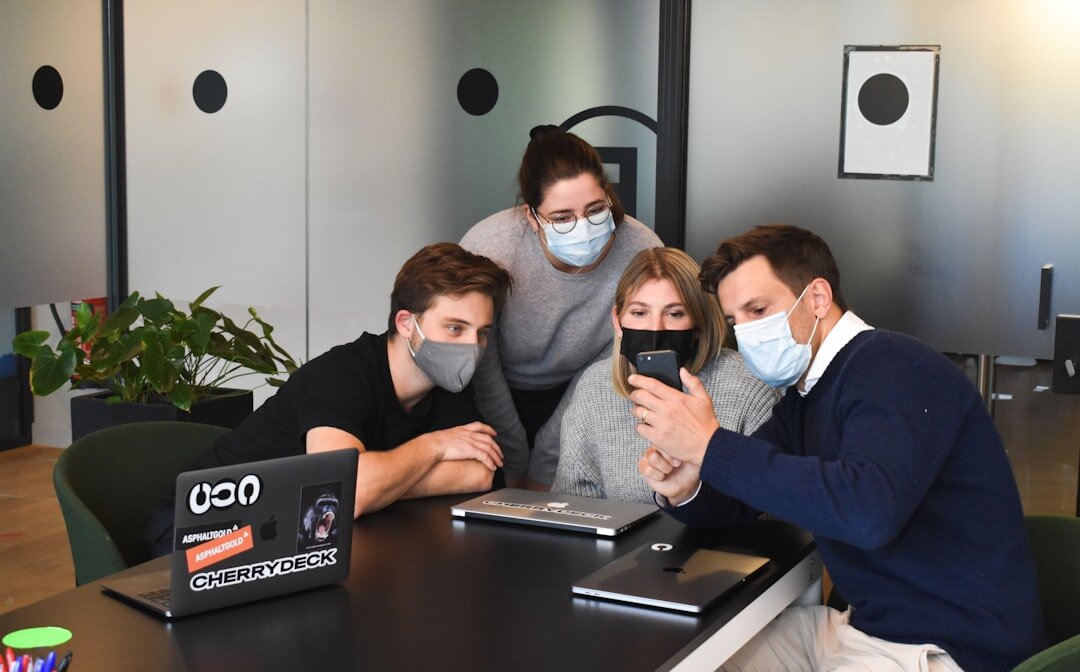 Team of video journalists reviewing footage on a laptop in an office