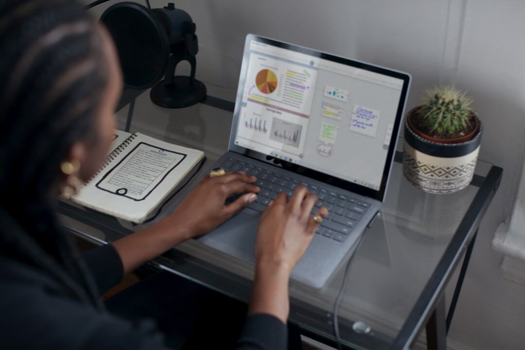 Person working on laptop with video content analytics and journalism metrics